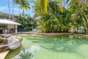 einen Pool in einem Resort mit Palmen in der Unterkunft 1 Bedroom @ Palm Villas #3 in Port Douglas