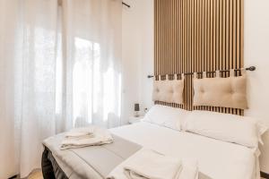 - une chambre avec un lit blanc et une tête de lit en bois dans l'établissement Casa Roma B&B, à Rome