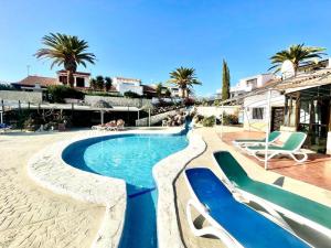 una piscina en una villa con palmeras en Bungalow Fairway Village in Golf del Sur en San Miguel de Abona