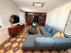 a living room with a blue couch and a television at Executive apartment - Oranjestad in Oranjestad