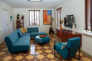 a living room with a blue couch and a tv at Executive apartment - Oranjestad in Oranjestad