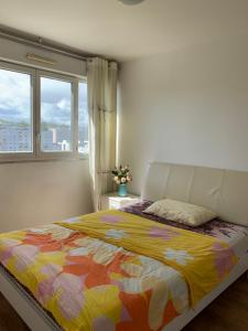 1 dormitorio con 1 cama con una manta colorida en 【Vitry-sur-Seine】 Appartements confortables de 2 chambres et 1 salon à louer en Vitry-sur-Seine