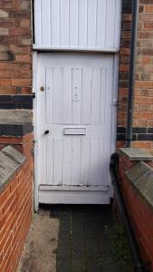 a white garage door on a brick building at Nice Double Bedroom Near QMC in Nottingham