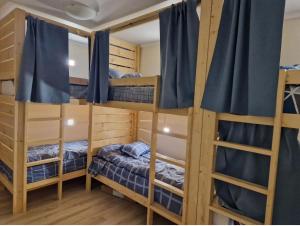 a room with three bunk beds with blue curtains at Hostel Buddha in Chişinău