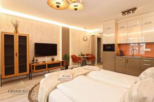 a living room with a bed and a kitchen at Grand Suites Promenade in Budapest