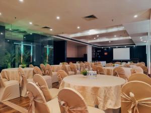 a banquet hall with tables and chairs and a screen at Regenta Central Grand Exotica in Pune