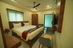 a bedroom with a bed and a flat screen tv at HOTEL ROI INN in Tirupati