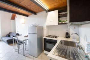 eine Küche mit einem Kühlschrank und einem Tisch in der Unterkunft Residenza Cherubini Varese Centro- IxiHome in Varese