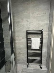 a shower with a towel rack in a bathroom at Pass the Keys - Beautiful Flat with balcony in Swiss Cottage, London in London