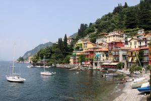 un grupo de barcos en el agua junto a los edificios en Tre Finestre Sul Lago, en Perledo