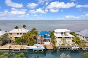 an aerial view of a house with a boat in the water at Haven House by Brightwild - Luxury Waterfront in Key West