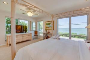 a bedroom with a large white bed and a view of the ocean at Haven House by Brightwild - Luxury Waterfront in Key West