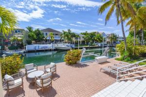 a patio with a table and chairs next to a body of water at Haven House by Brightwild - Luxury Waterfront in Key West