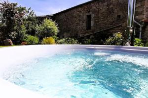 uma grande piscina de água azul num quintal em Le petit paradis aux volets bleus em Grazac