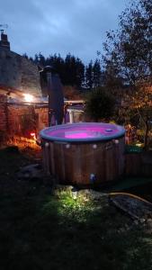 uma banheira de hidromassagem sentada no pátio à noite em Le petit paradis aux volets bleus em Grazac