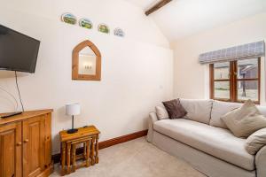 a living room with a couch and a tv at Well Cottage - Compact & Cosy! in Buckinghamshire