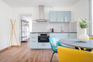 アニエール・シュル・セーヌにあるPerfect flat for 4 people #7の白いキャビネット、テーブル、黄色の椅子が備わるキッチン