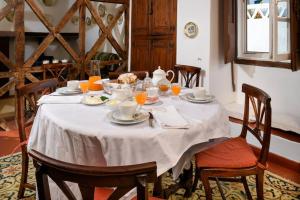 een tafel met een witte tafeldoek erop met sinaasappelsap bij Casa De Santiago in Santiago do Cacém