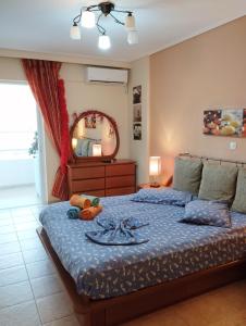 a bedroom with a bed with a blue comforter and a mirror at Dancer's Home in Korinthos