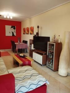 uma sala de estar com uma televisão e uma mesa em Dancer's Home em Corinto