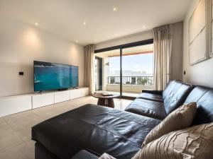 マルベーリャにあるSamara Resort Gym Spa Jacuzzi Pools Marbellaのリビングルーム(黒い革張りのソファ、薄型テレビ付)