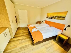 een slaapkamer met een groot bed met een oranje hoofdeinde bij Landhaus Immenbarg, Auszeit in Warnemünde