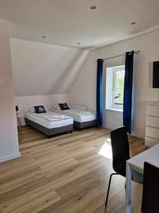 two beds in a room with a wooden floor at Pokoje u Emilii ul. Warszawska in Mikołajki