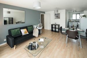 a living room with a black couch and a table at Lovely one bed flat London Bridge in London