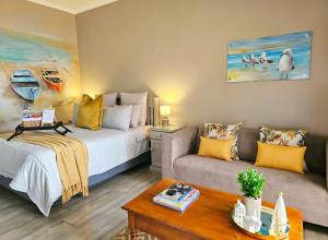 sala de estar con cama y sofá en Bliss on JBay - Blissful, en Jeffreys Bay