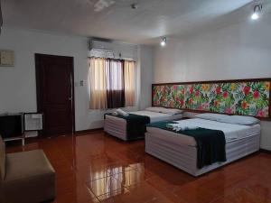 a room with two beds and a couch and a television at Big Brother Condotel in Puerto Princesa City