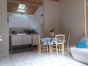 a kitchen with a table and chairs in a room at Gite de la melisse in Lairière