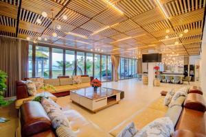 uma grande sala de estar com sofás e uma mesa em Golden Beachside Resort Danang em Da Nang