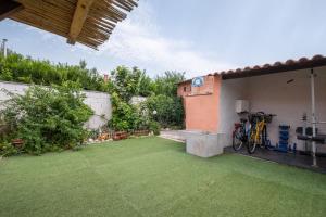 un piccolo cortile con un cortile con prato verde di Villa Vintage con giardino e palestra a Riola Sardo