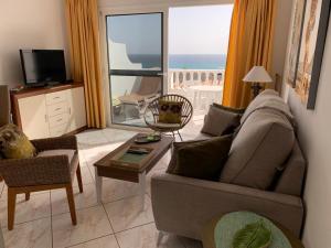 un salon avec un canapé et une vue sur l'océan dans l'établissement Apartamentos Bahia Playa. Costa Calma., à Costa Calma 14 autres photos