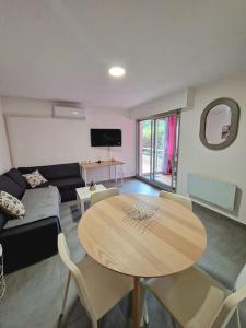 a living room with a table and a couch at Rez-de-jardin sous pins et plage in Saint-Mandrier-sur-Mer