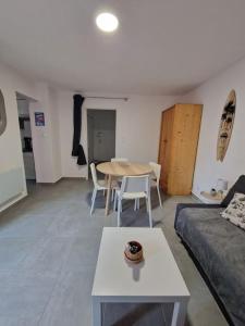 a living room with a table and a couch at Rez-de-jardin sous pins et plage in Saint-Mandrier-sur-Mer