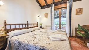 a bedroom with a large bed and a large window at Apartamentos de turismo rural Buena Vista in Cangas de Onís
