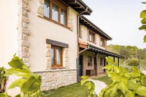una casa con fachada de piedra y ventanas en Apartamentos de turismo rural Buena Vista, en Cangas de Onís