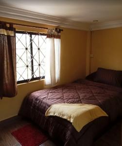 a bedroom with a bed and a window at One Piece Kampot in Kampot