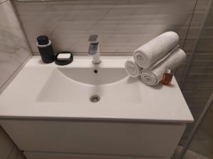 a white bathroom sink with towels and a faucet at צ'יל ורוגע עם ג'קוזי וגינה פרטית in Bayit Wegan