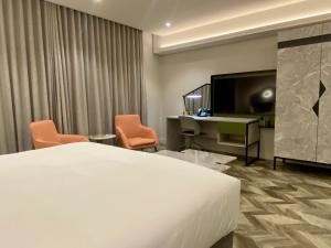 a hotel room with a bed and a desk and a television at Coastlands Skye Hotel, Ridgeside, Umhlanga in Durban