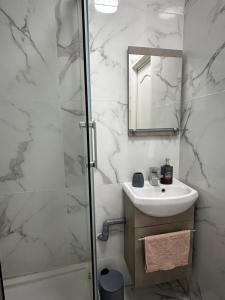 a white bathroom with a sink and a shower at Ourasi - Hippodrome de Vincennes - Netflix in Saint-Maurice +10 photos