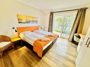 a bedroom with a bed and a large window at Landhaus Immenbarg, Wellness in Warnemünde