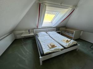 Cama en habitación pequeña con ventana en Ferienhaus Beja, en Winterberg