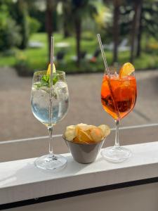 two wine glasses and a bowl of food on a table at Hotel Lamm in Naturno