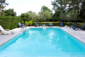 a swimming pool with chairs and a table in a yard at Villa Plavo more Fiorini in Umag