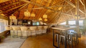 um bar com bancos num quarto com tectos em madeira em Unyati Safari Lodge em Hectorspruit