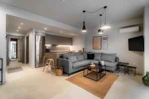 Una sala de estar con un sofá y una cocina. en Speiō Luxury House, en Heraclión