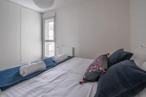 um quarto com uma cama com almofadas em NATHAN - Appartement proche gare arrivée 2424 em Le Mans