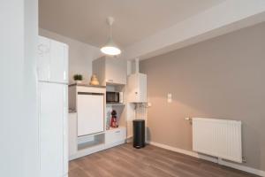 uma cozinha com armários brancos e um frigorífico em NATHAN - Appartement proche gare arrivée 2424 em Le Mans